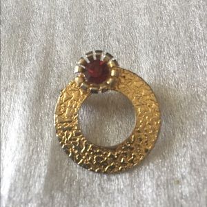 Pin goldstone with red stone